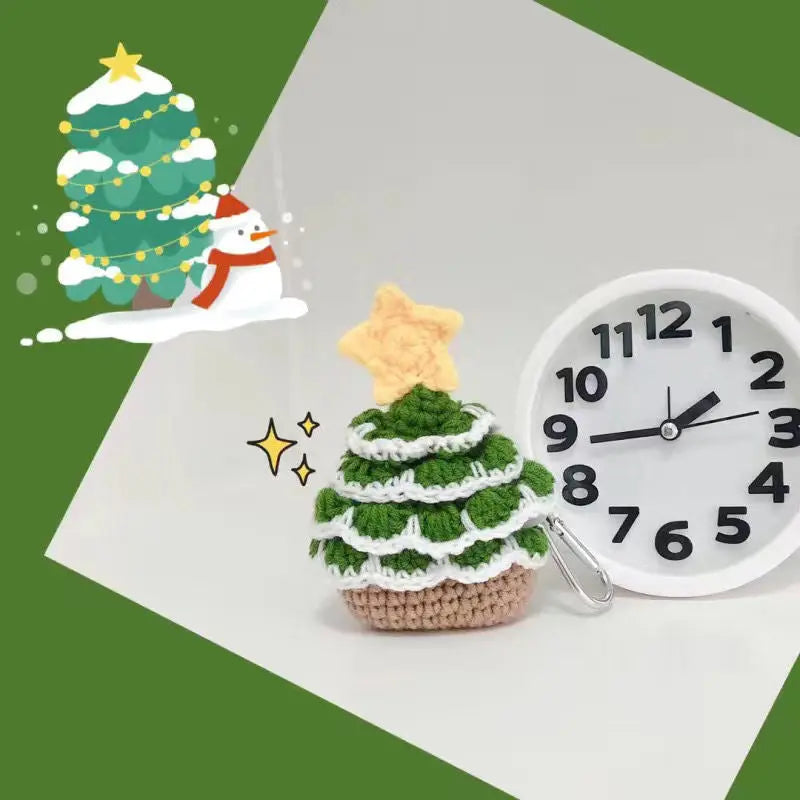 A crochet Christmas tree with a yellow star on top, set against a green and white background, surrounded by a clock and other festive decorations.