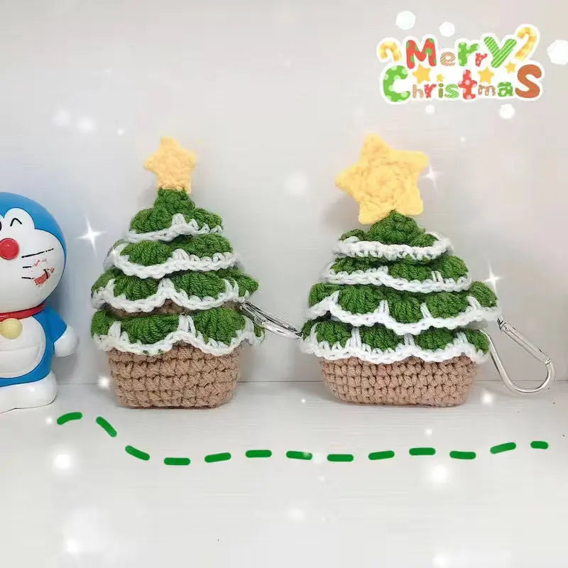 Two crochet Christmas trees with yellow stars on top, alongside a blue Doraemon plush toy, with 'Merry Christmas' text above.