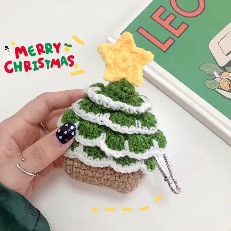 A crochet Christmas tree with a yellow star on top, made from green, white, and brown yarn, with 'MERRY CHRISTMAS' text in the background.